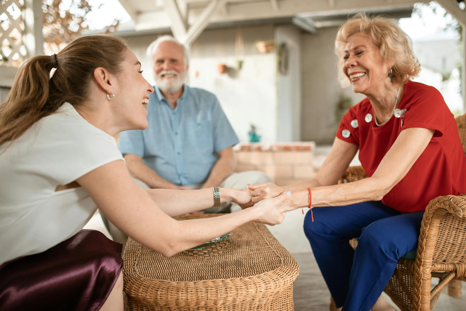 Alltagsengel plus - Alltagshelfer - Dieses Bild zeigt einen Moment der Verbundenheit und Freude zwischen einer jüngeren Person und einem älteren Paar, während sie sich lebhaft unterhalten.
